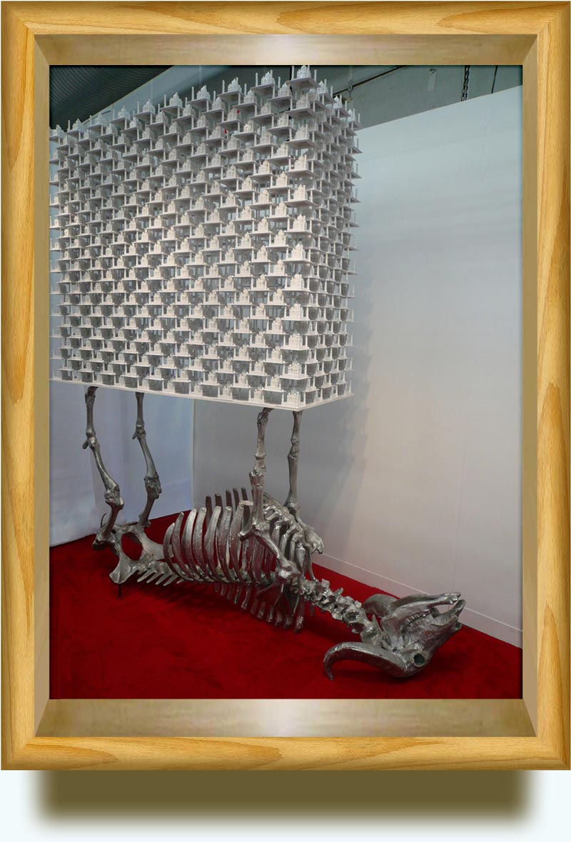 Sudarshan Shetty (b. 1961 in Mangalore, India. Currently based in Mumbai). No Title. Aluminum cow skeleton 278×152×55.5 cm and structures of toy PVC Taj Mahal-esque buildings, stacked in offset blocks. Armory Show 2008, NYC.